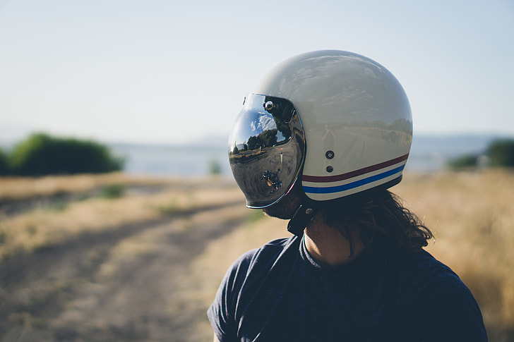 person wearing white, red, and blues tripe half-face helmet during daytime