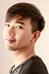 pixie-cut man wearing black and gray top