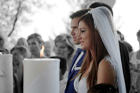 photo of man in blue notched lapel suit jacket and woman in white wedding gown