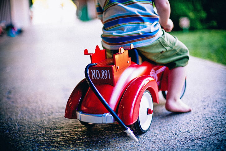 toddler riding red and orange ride on toy
