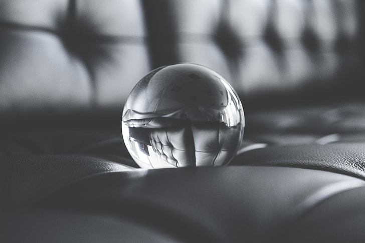 Big Glass Crystal Ball on Black Leather Sofa