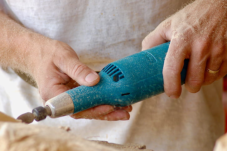 person holding brown rotary tool closeup photography