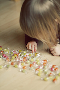 girl playing with candies on floor