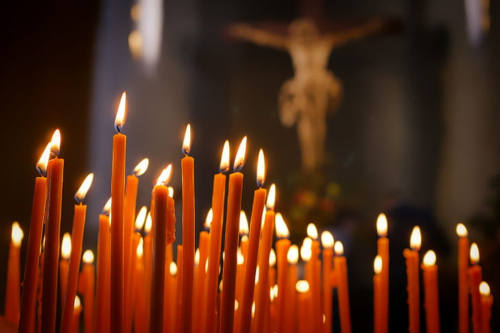 lighted candle near crucifix photo