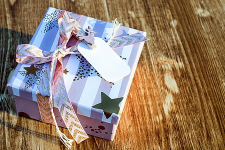 white and pink gift box on brown wooden surface