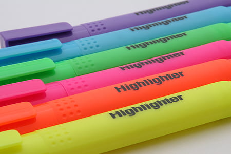 six assorted Highlighter pens on top of white surface
