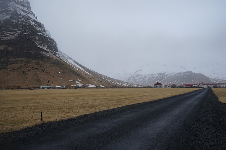 black asphalt road near rocky mountain
