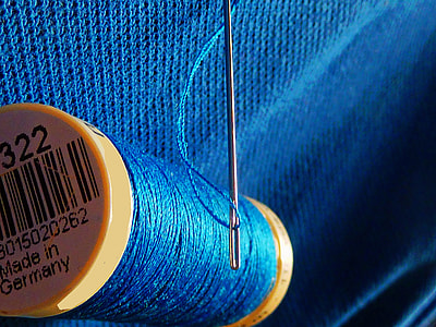 closeup photo of blue thread and needle