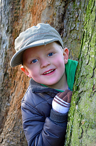 boy peeping from a tree