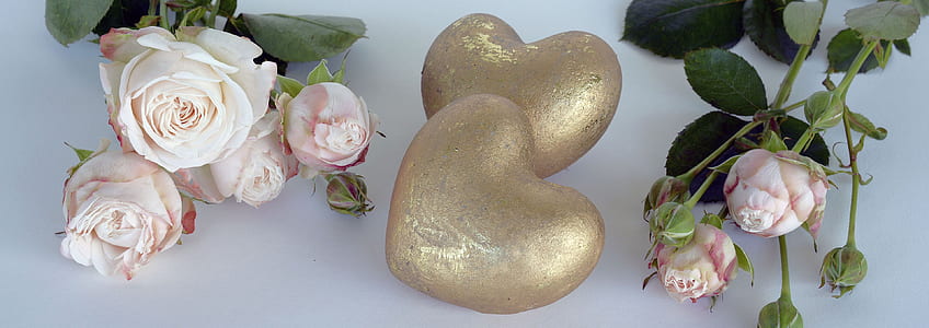 two heart gold decors beside pink petaled flowers