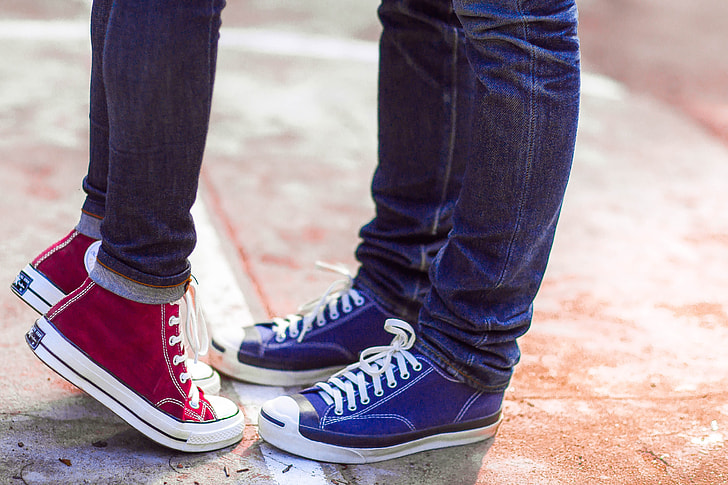 Royalty-Free photo: Two person wearing blue denim jeans, blue and red  high-top sneakers standing | PickPik
