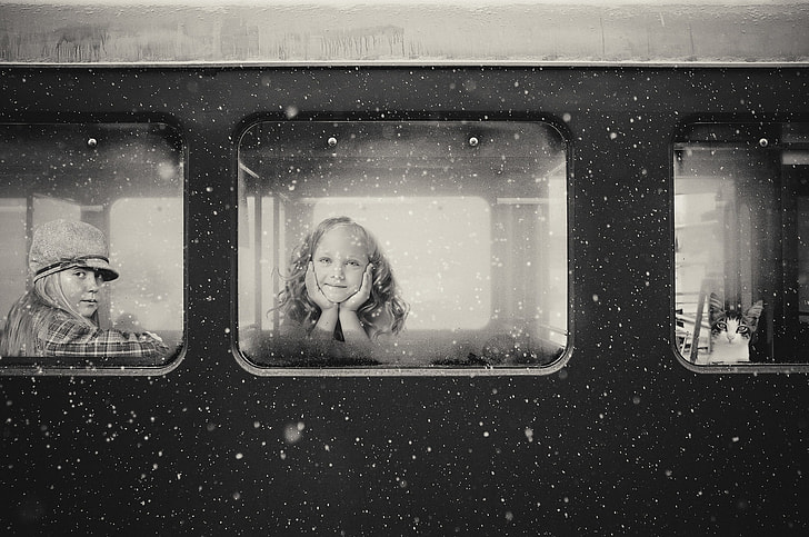 grascale photo of girl inside train