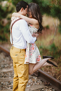 man and woman hugging on train rail
