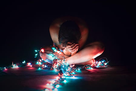 naked person surrounded by lighted string lights
