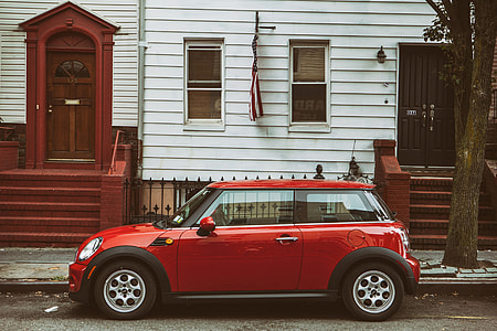 Street shot of a red Mini car sitting on the road in a quiet area of Brooklyn, New York City