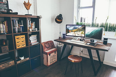 two white flat screen computer monitors on brown wooden table