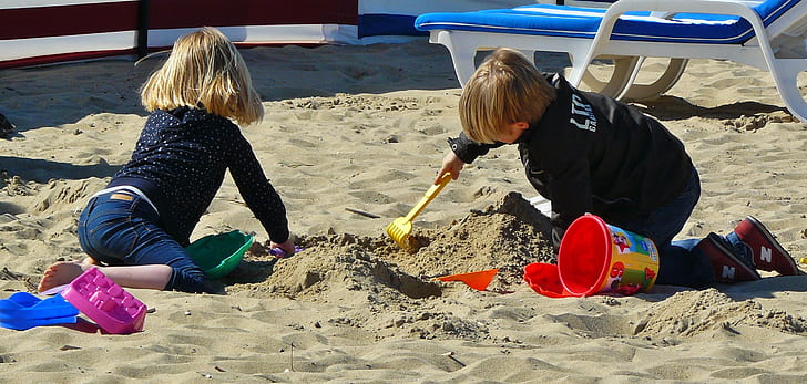 two children crawling on sand