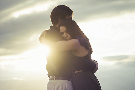 woman and man hugging at sunset
