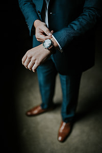 man in suit jacket fixing his cuff
