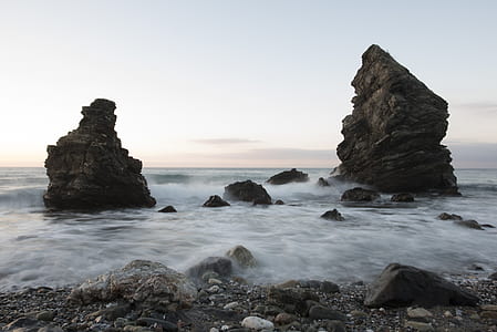 time lapse photography of body of water and rock formation