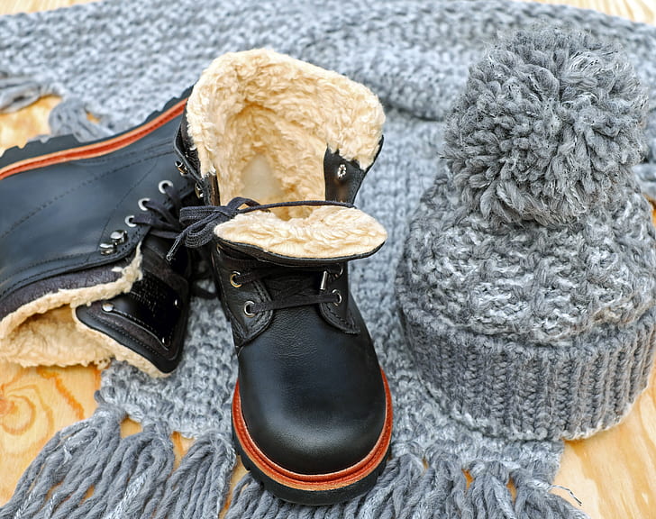 pair of black leather work boots and gray crochet beanie
