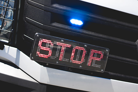 Police Flashing Light and STOP Sign on Car