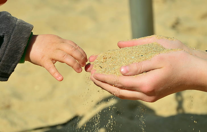 brown sand on person's hand