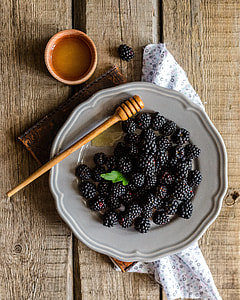 black berries on white ceramic plate on brown table top