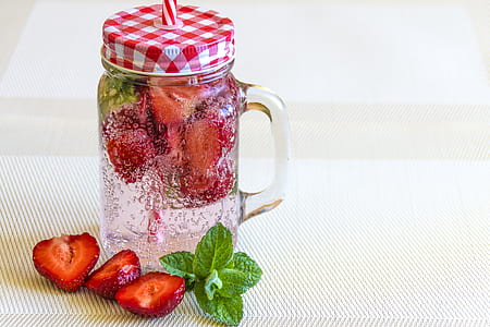 strawberries on clear glass mason jar