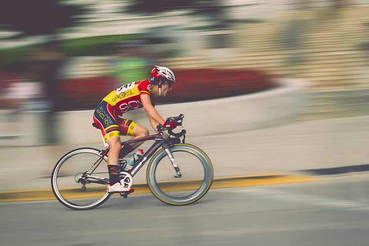 man in yellow and red on bicycle