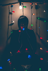 Man Sitting on Chair With Multi-colored String Lights