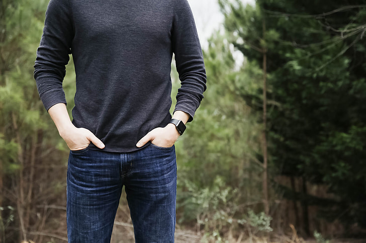 person wearing blue jeans standing on forest