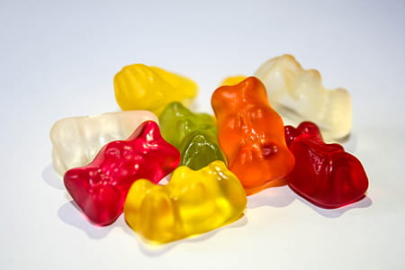 assorted-color gummy bears on white surface