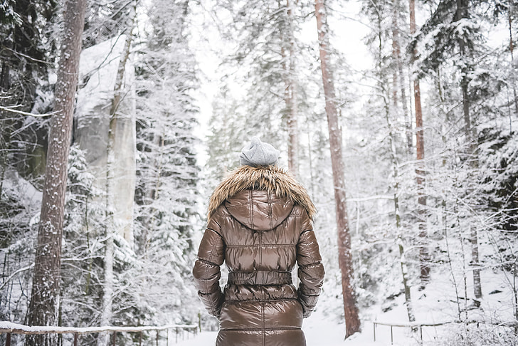 Girl in Winter Jacket Walking in Snowy Forest