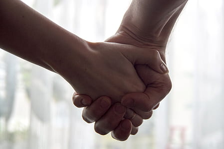 selective focus photography of man and woman holding each other's hands
