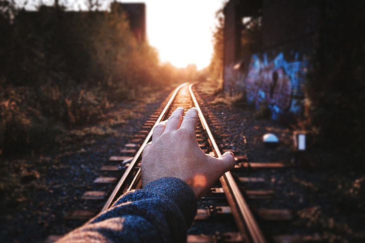 Man’s hand on train tracks