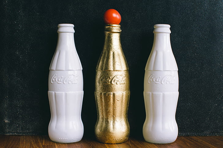 Three White and Brass Coca-cola Bottles