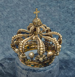 gold-colored crown on gray cushion