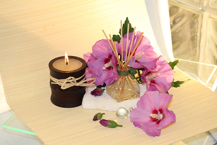 purple flower beside beige candle