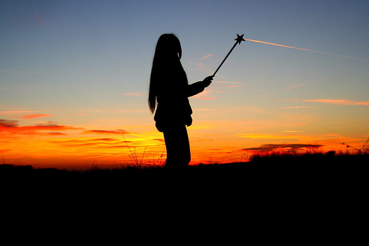 silhouette of woman holding star stick during dawn