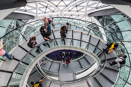 Various people using the helical walkway at City Hall in London. City Hall is the headquarters of the Greater London Authority (GLA), which comprises the Mayor of London and the London Assembly. Situated in Southwark, on the south bank of the River Thames. It was created by Norman Foster and opened in July 2002, two years after the Greater London Authority was created