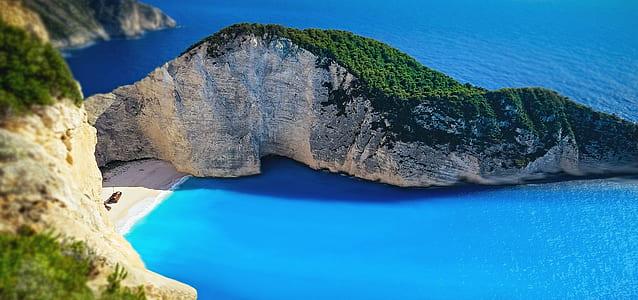 bird's eye view of mountain beside blue body of water
