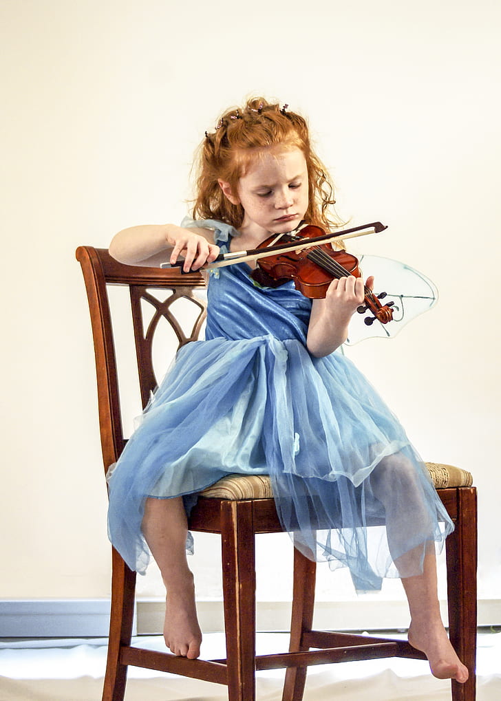 girl wearing blue dress playing violin