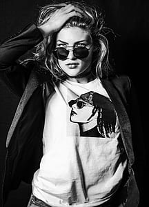 grayscale photo of woman in black coat and black sunglasses with black frames