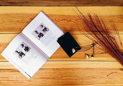opened book on brown wooden table