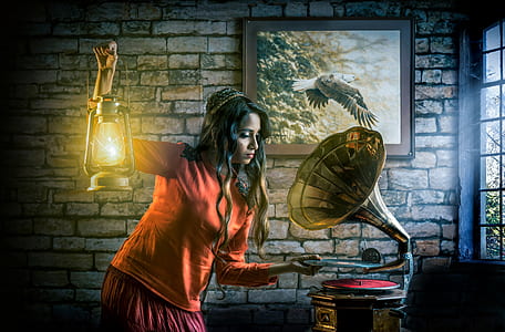 woman holding kerosene lantern standing beside the gramophone