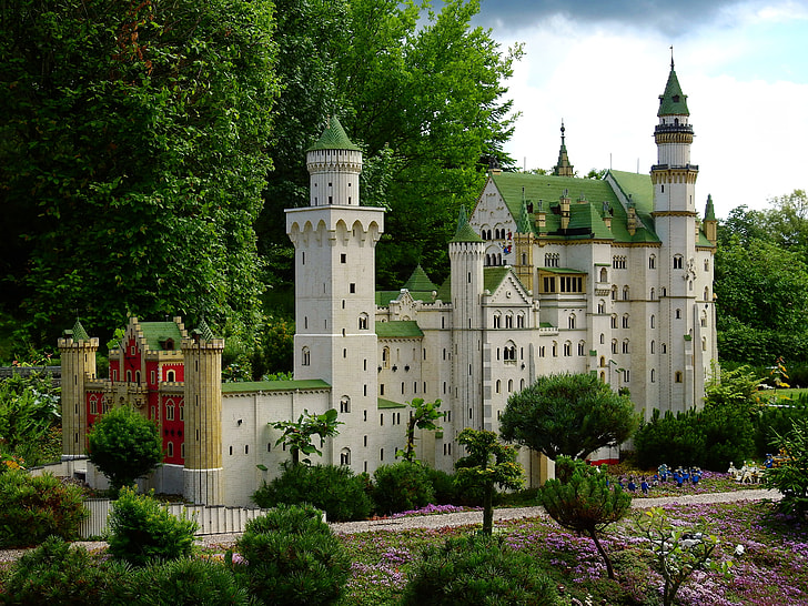 white and green castle surrounded by trees during daytime