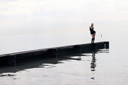 woman standing on beach dock
