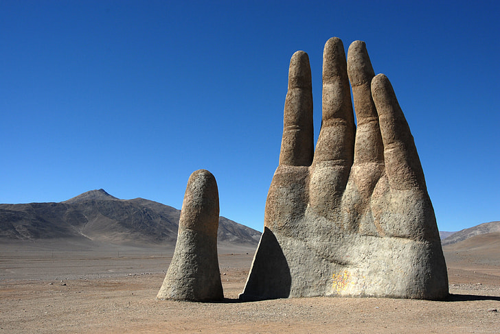 gray concrete human hand statue