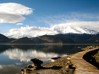 lake and mountain under blue sky with white clouds view during daytime